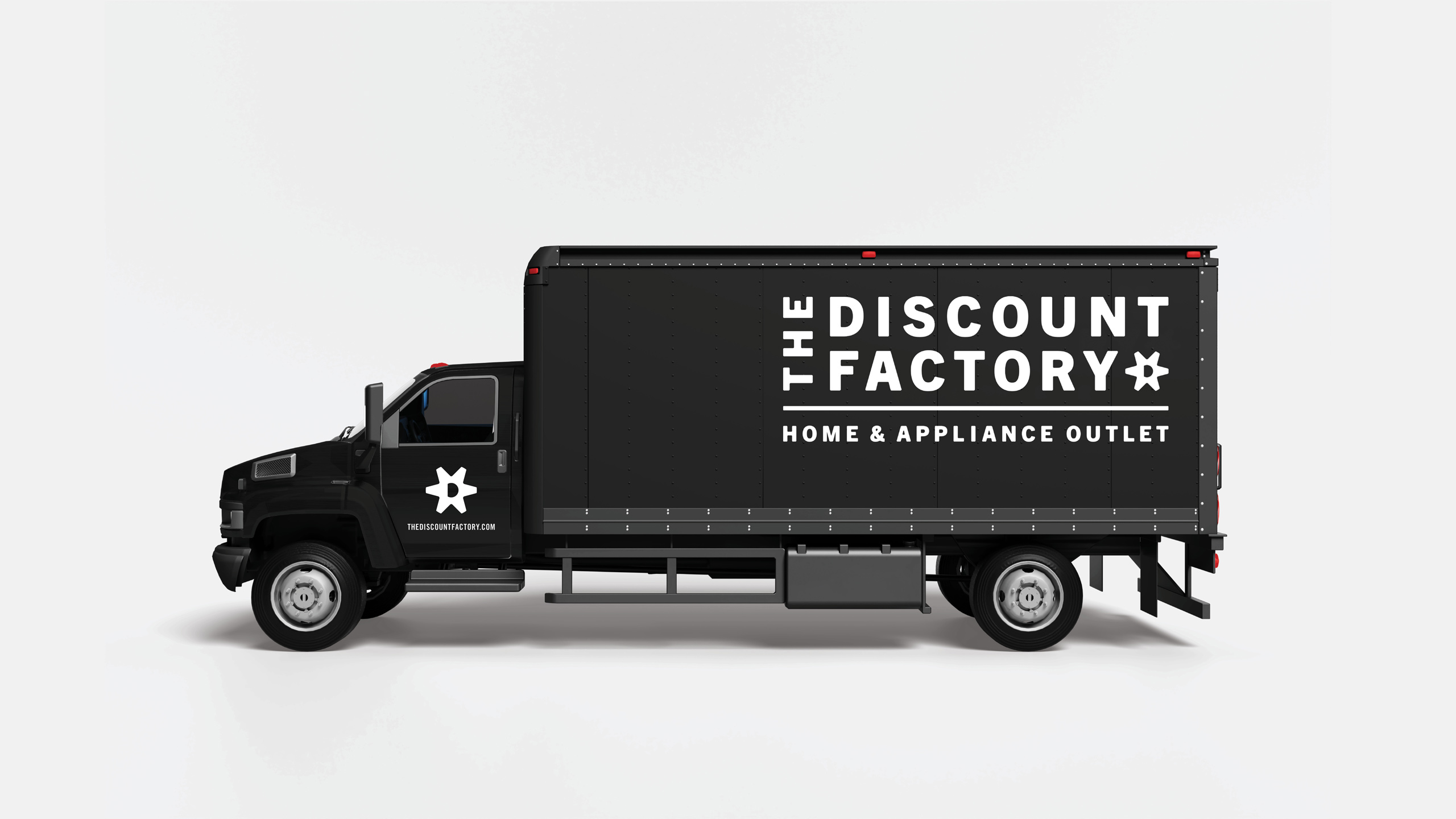 A black delivery truck with "The Discount Factory" and "Home & Appliance Outlet" in bold white text is parked against a plain light gray background.
