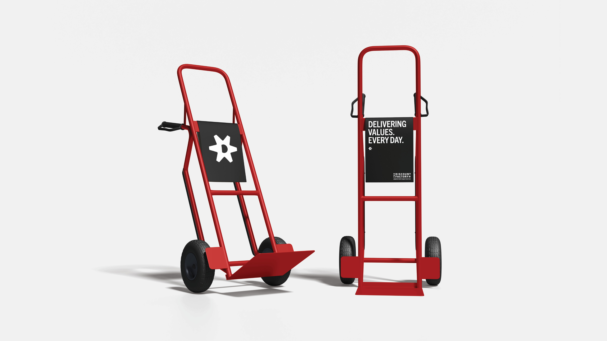 Two red hand trucks stand side by side against a white background. The left one has a white star logo, and the right displays "Delivering Values Every Day."
