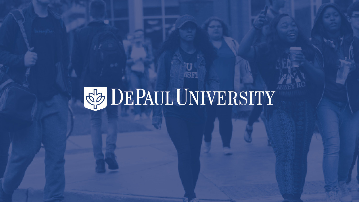Students in casual attire walk on a busy campus sidewalk at DePaul University. The image has a blue tint and conveys a lively college atmosphere.