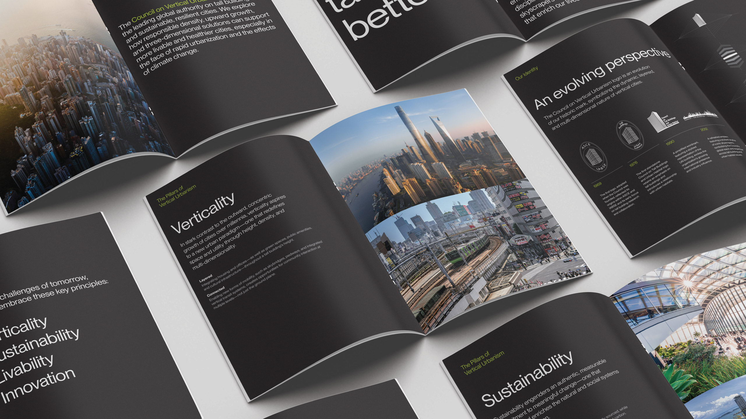 Open magazines are spread out showcasing pages from the Council on Vertical Urbanism brochure. The pages feature skyscraper photos and text on verticality, sustainability, and innovation.