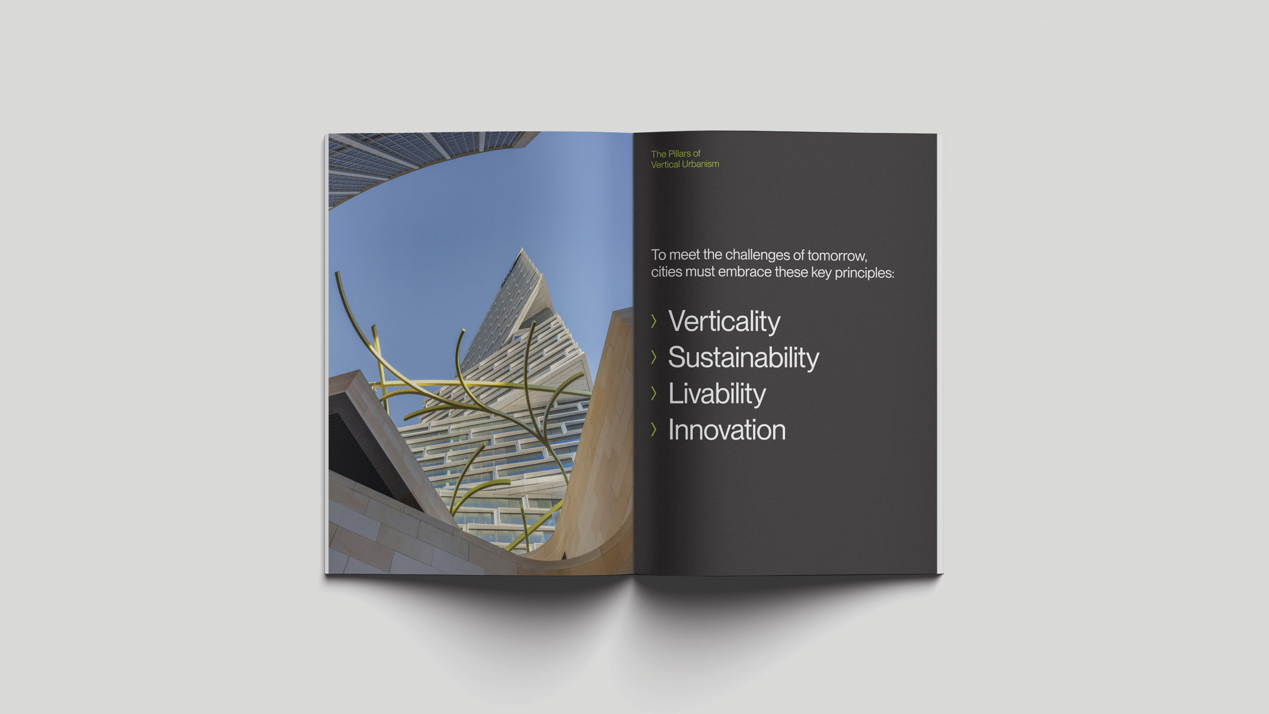 Open book layout featuring a photo of modern skyscrapers with artistic metal sculptures on the left. The right page lists principles: Verticality, Sustainability, Livability, Innovation.